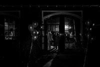zwart wit foto van ingang feestzaal met gasten binnen
