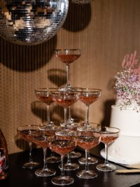 close up champagnetoren met roze champagne en discobal