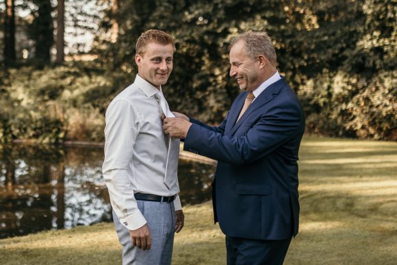 Bruidegom met vader die stropdas om doet