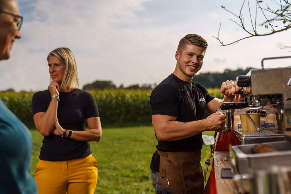 barrista bij koffiebar met gasten ernaast